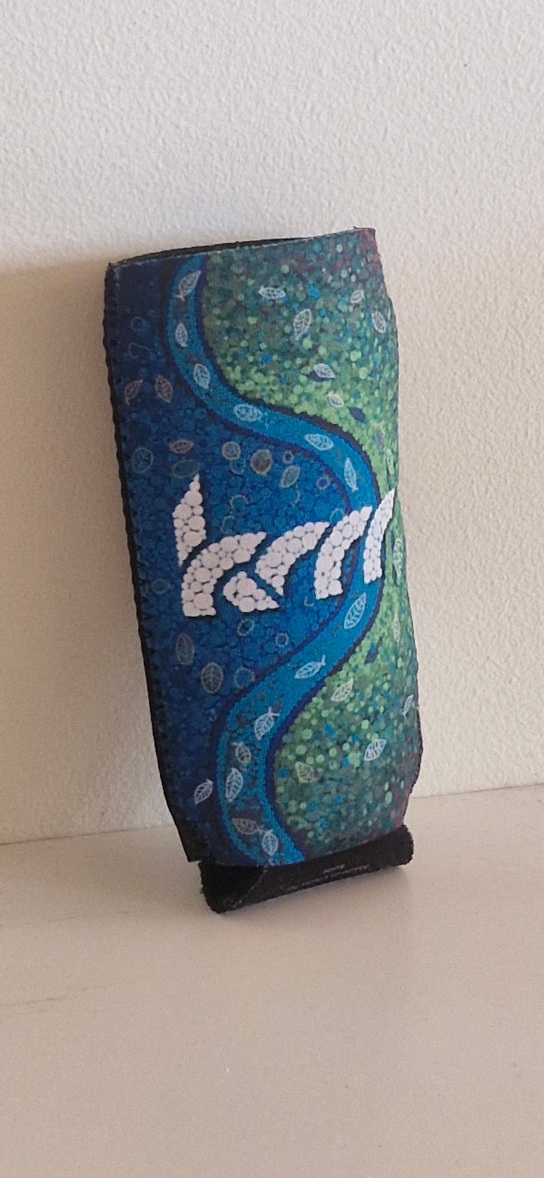 Blue and green patterned pouch designed to fit a koor bottle on a light beige background